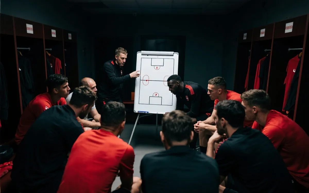 更衣室战术板与球员围成一圈，专注与团队感，纪实风格